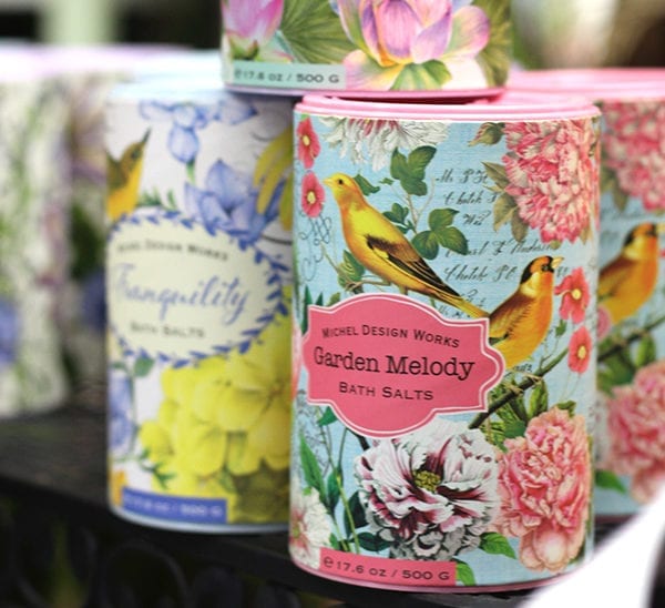 A set of home fragrances in decorative, floral, cylindrical containers