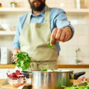 man cooking with herbs